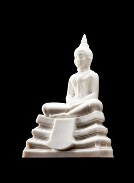 White Buddha statue for worship on the set of altar table, isolated on black background