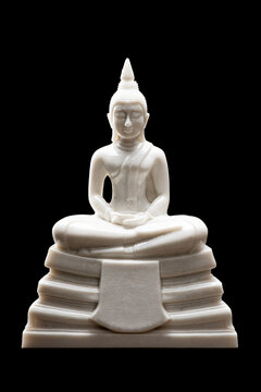 White Buddha statue for worship on the set of altar table, isolated on black background