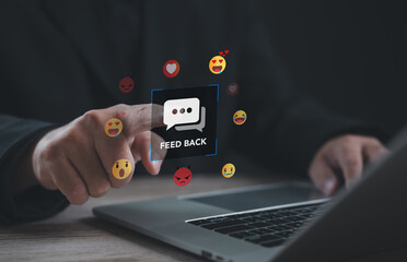Office worker using laptop to provide digital feedback with emoji reactions, representing customer engagement, online review, satisfaction, communication, and social media interaction.