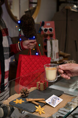 Customer receiving shopping bag and enjoying eggnog during christmas