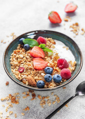 Granola bowl with yogurt, berries, and nuts for breakfast