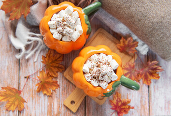 Pumpkin mugs filled with hot chocolate warming up for fall