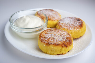 Cheesecakes with sour cream on a white plate