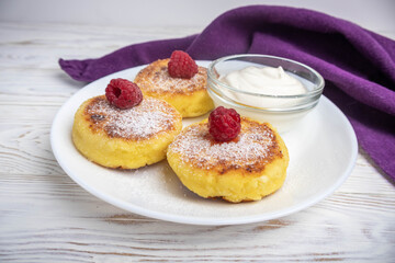 Cheesecakes with sour cream on a white plate