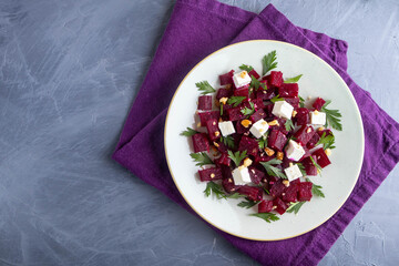 Delicious bright salad with beetroot, arugula, and feta on a light background