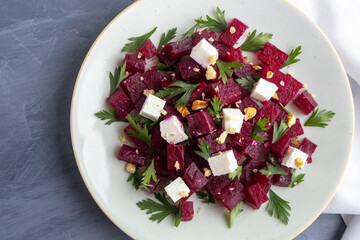 Delicious bright salad with beetroot, arugula, and feta on a light background