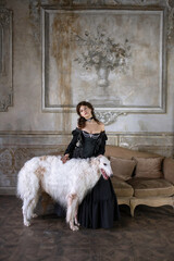 An elegant girl with a beautiful greyhound dog in a vintage interior