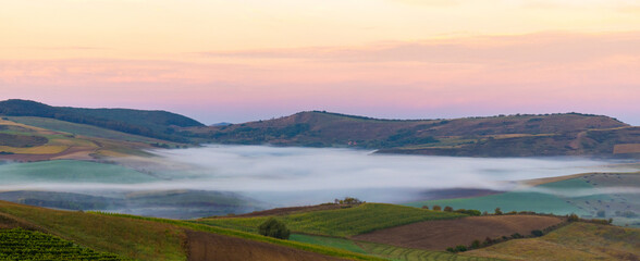 Landscape with fog between hills in the morning