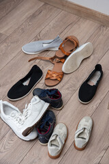 pile of women's and children's and teenage shoes lies on the floor, clean and dirty, worn. Decluttering and cleaning