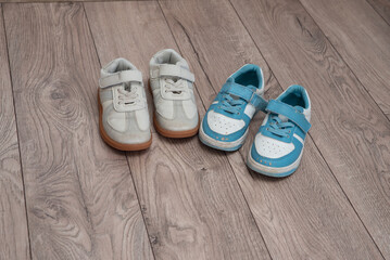 Two pairs of worn but clean children's shoes stand on the floor. Teaching children to be tidy