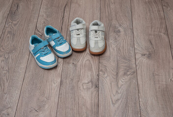 Two pairs of worn but clean children's shoes stand on the floor. Teaching children to be tidy