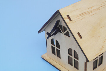 Close up of military drone hits house on blue background. Concept of drones attack houses.