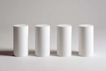 Four white cylinders on a light gray background