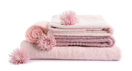 Stack of fresh terry towels and flowers isolated on white