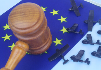 Many military drone, judge gavel and European Union flag. Concept of laws against accidents with...