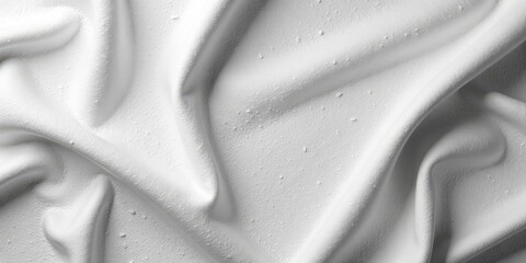 Draped white fabric with a textured surface and subtle water droplets, showcasing elegant folds and soft shadows