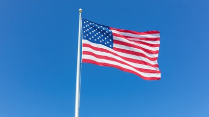 Fototapeta premium Waving american flag clear blue sky patriotic symbol
