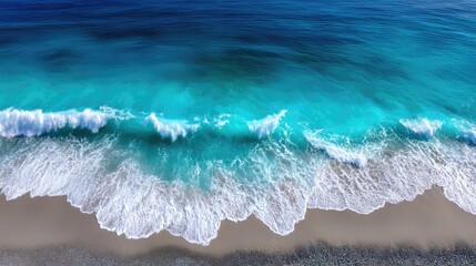 Aerial View of Turquoise Ocean Waves Crashing on Sandy Beach with Dark Pebbles in Bright Sunlight