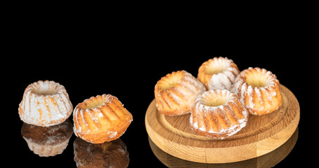 Sweet homemade cupcakes isolated on black background, close-up.