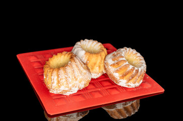 Sweet homemade cupcakes isolated on black background, close-up.