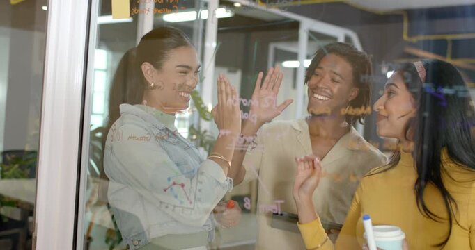 Diverse coworkers uncapping markers and sketching project timeline on whiteboard at modern office