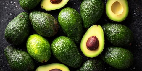 Fresh avocados arranged on a dark surface