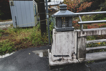 Obraz premium Traditional Japanese Stone Lantern on Old Bridge in Countryside