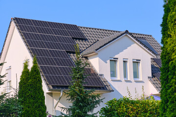 Modern residential house with solar and heat panels on sunny roof, showing renewable energy use and sustainable architecture in Rostock, Germany