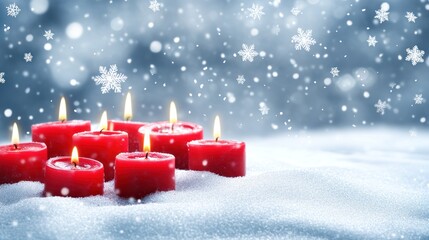 Burning red candles in snowy winter scene