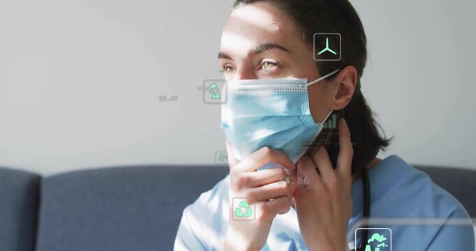 Healthcare worker pulling, smoothing mask edges for fit during head turn revealing green data icons