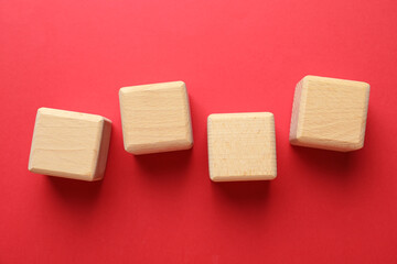 Blank wooden cubes on red background, flat lay