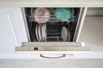 Open dishwasher with clean plates and bowls in kitchen setting.
