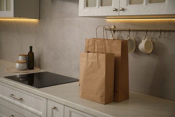 Paper bags on white counter in kitchen. Space for text