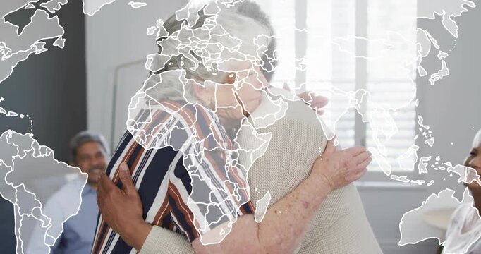 Senior woman rising and hugging peer inspiring community clapping with world map overlaying frame