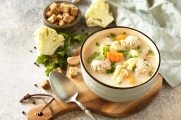 Hearty meatball soup with vegetables and herbs for a cozy meal.