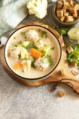 Hearty meatball soup with vegetables and herbs for a cozy meal.
