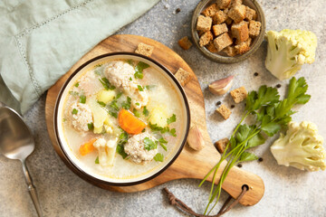 Hearty meatball soup with vegetables and herbs for a cozy meal.