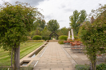 Obraz premium A well-kept garden with a stone path, seating area, and green hedges. The tranquil atmosphere invites you to linger.