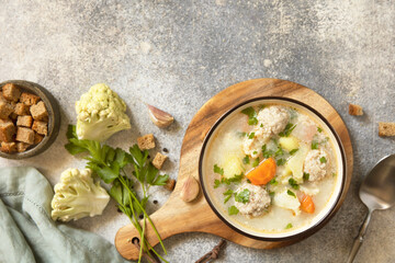 Hearty meatball soup with vegetables and herbs for a cozy meal.