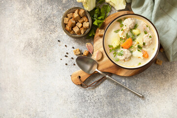 Hearty meatball soup with vegetables and herbs for a cozy meal.