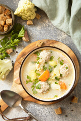 Hearty meatball soup with vegetables and herbs for a cozy meal.