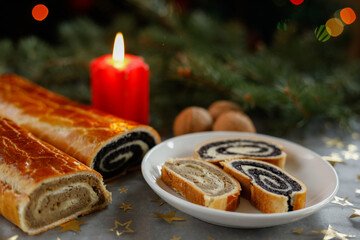 Sliced Christmas walnut and poppy seed rolls with candle