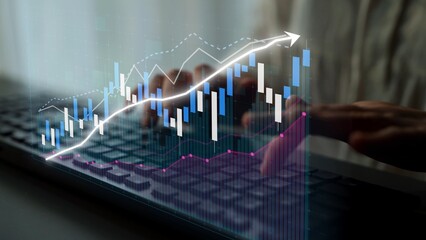 A close-up view of hands typing on a laptop keyboard with an overlaid financial graph showcasing market trends and data visualization for modern business analytics. Copula