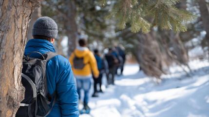 A snowshoe guide leads a group through woods paths pointed out hikers following bokeh from tree trunks adding wilderness adventurous winter outdoor tour with copy space