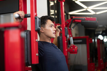 A man practicing chest and arm strength on equipment, close-up shot