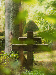 Auf dem Parkfriedhof steht ein altes Holzkreuz, mildes weiches Gegenlicht