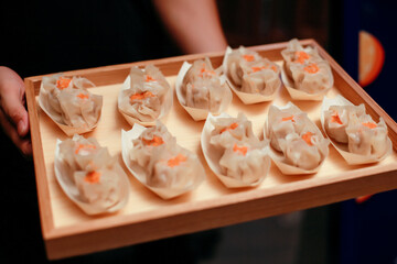 Delicious Asian dim sum dumplings on a wooden tray