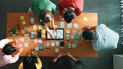 Top view of developer team working together to write idea about Ux ui design on colorful sticky note. Group of programmer looking at wireframe prototype at tablet and designing software. Convocation.