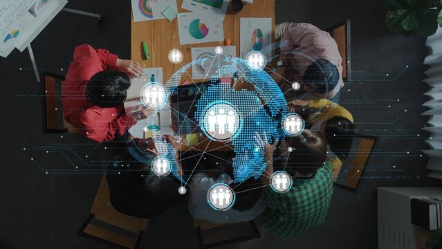 A diverse group of individuals collaborates on a business project, utilizing charts and global network visuals in a modern office setting, symbolizing teamwork and innovation. Raster - Powered by Adobe