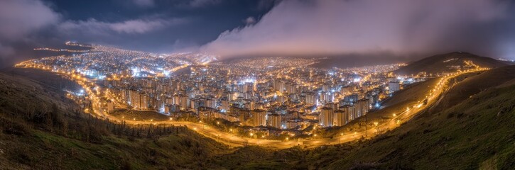 Obraz premium A sprawling city, illuminated at night, nestled within a valley, framed by a hillside, bathed in a soft, warm light.
